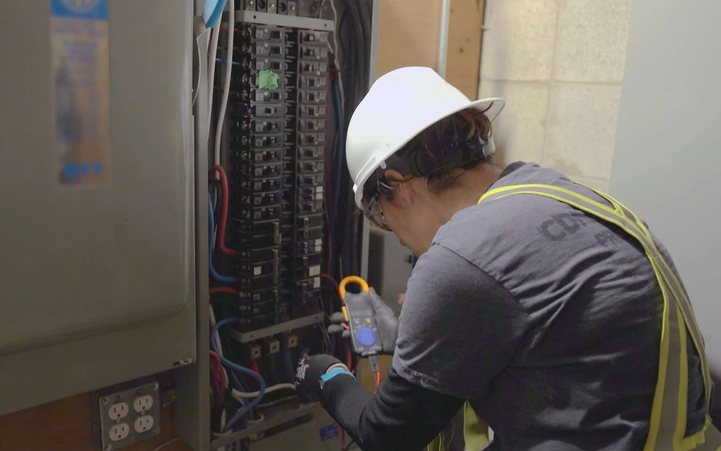 Electrician testing an electrical panel on a commercial jobsite