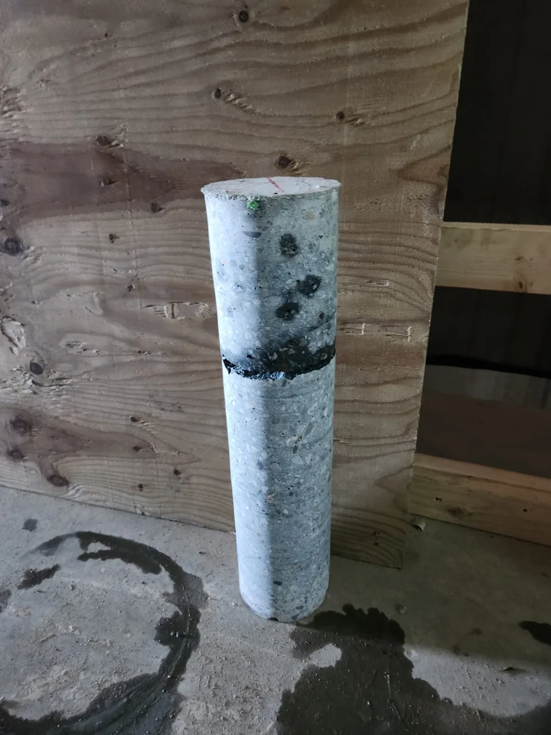 Extracted cylindrical concrete core standing on site