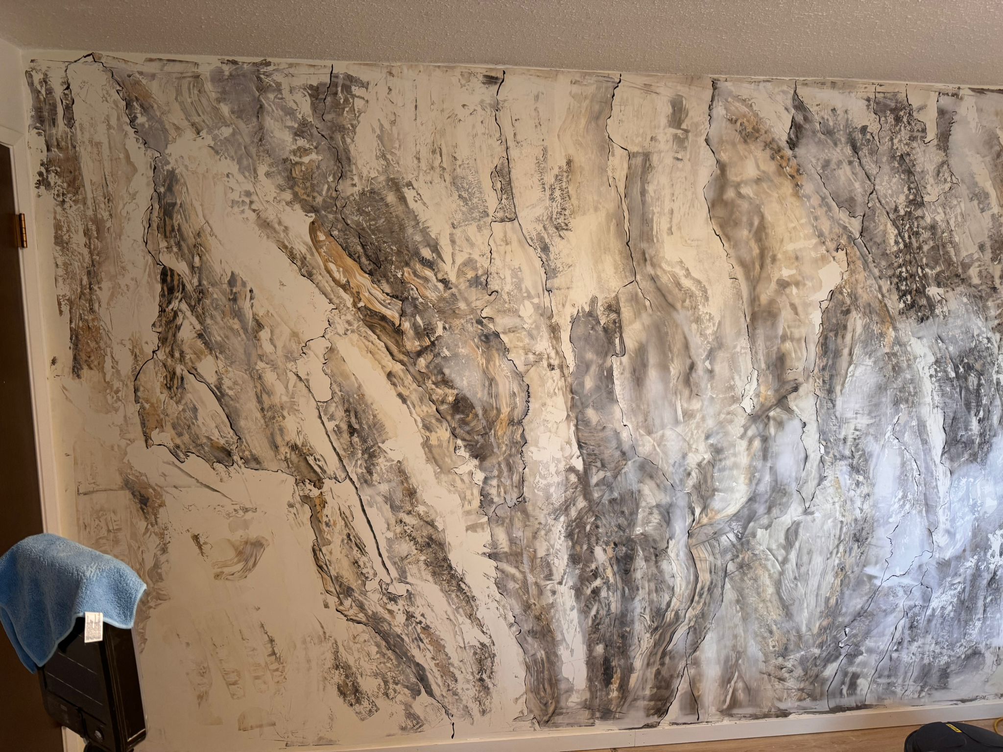Hand-textured decorative accent wall with a stone-and-gold plaster finish