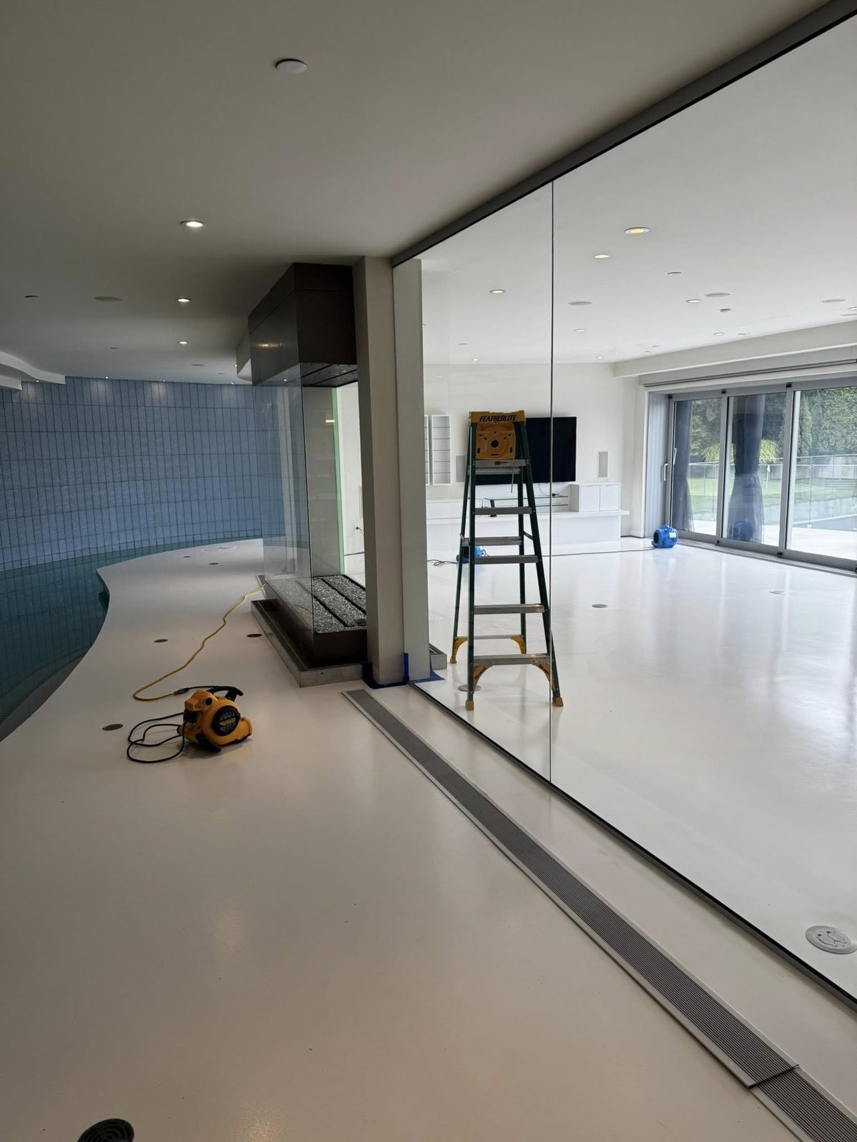 Indoor pool room with mirrored glass wall prepared during luxury home preparation in Jericho Beach