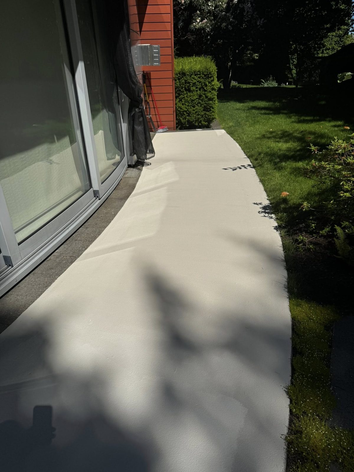 Recoated exterior concrete walkway beside repainted stucco wall at a Jericho Beach estate